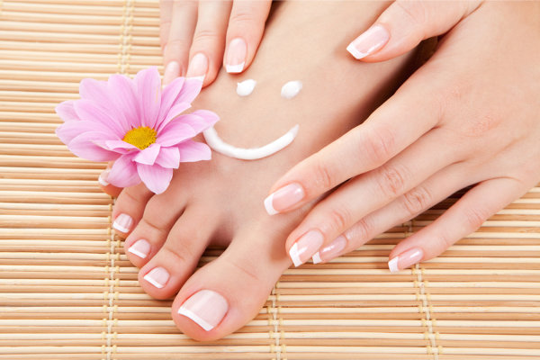 Woman applying lotion to her foot.  Lotion has been applied as a smiley face.