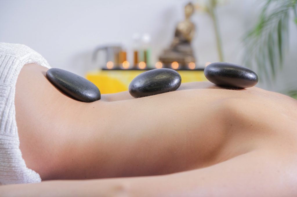 woman at spa receiving a hot stone massage